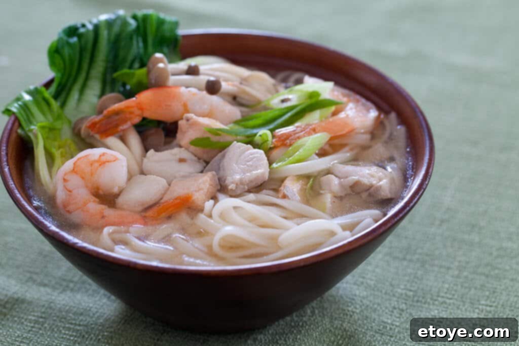 seafood noodle soup in brown bowl