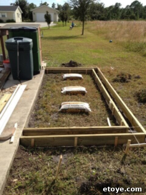 Chicken Coop Footer Preparation Framed concrete footer for the chicken coop, showing rebar and drainage stones.