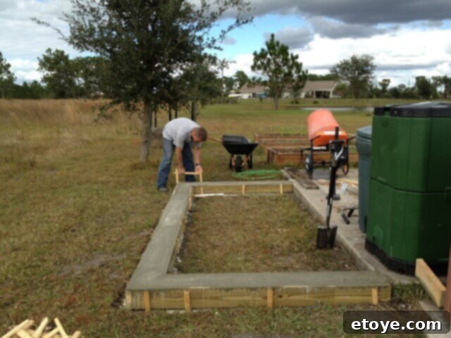 Chicken Coop Concrete Pour Freshly poured concrete footer for the chicken coop, showing the smooth, wet surface.
