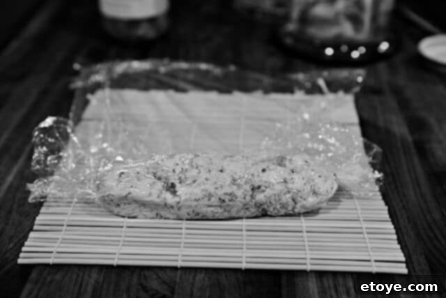 Fiery Kimchi Butter Steak 6 Partially rolled kimchi butter in plastic wrap, showing the initial log formation.