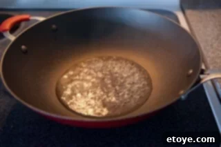 green-bean-mushrooms-stirfry-recipe-7135 Steaming green beans in a wok, preparing them for stir-frying.