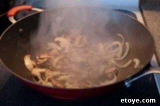 Savory Shiitake and Green Bean Stir-Fry 3 Sautéing onions and mushrooms in a hot wok for the stir-fry.