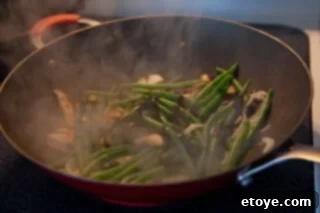 Savory Shiitake and Green Bean Stir-Fry 5 Stirring in oyster sauce and water to create a savory glaze.