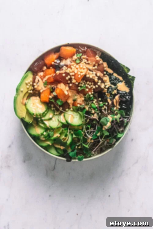 Irresistible Tuna and Salmon Sushi Bowl with Spicy Mayo 2 Top view of a vibrant Tuna and Salmon Sushi Bowl, garnished with fresh ingredients and spicy mayo.