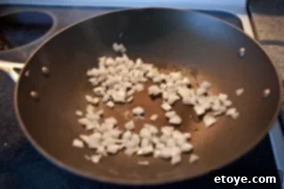 Spicy Miso Steamed Mussels 3 Sautéing onions and garlic in a wok for miso broth