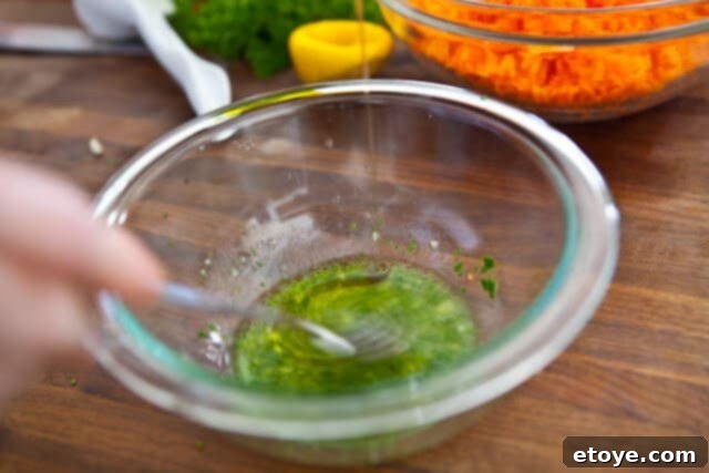 French Carrot Fennel Salad Recipe Whisking together the fresh lemon, olive oil, herbs, and seasonings for the French Carrot Fennel Salad dressing
