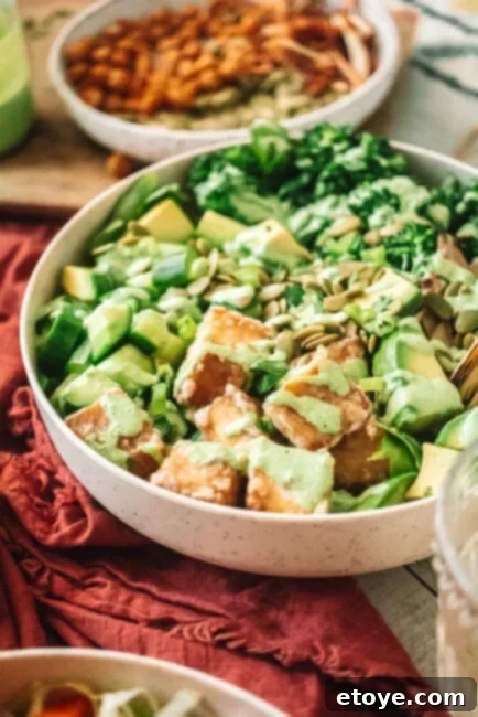 Close-up of a Green Goddess Tofu Bowl with a generous drizzle of dressing, showcasing fresh ingredients