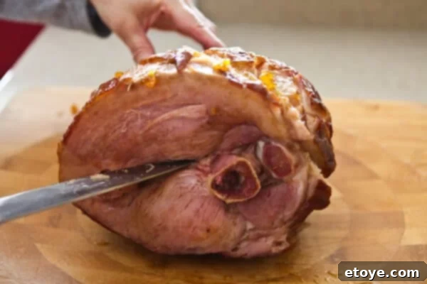 Sweet and Savory Easter Ham with Grilled Peaches 14 cutting through cooked ham