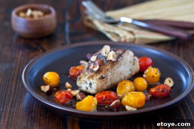 Close-up of Flaky Cod Fillet with Browned Butter and Hazelnuts