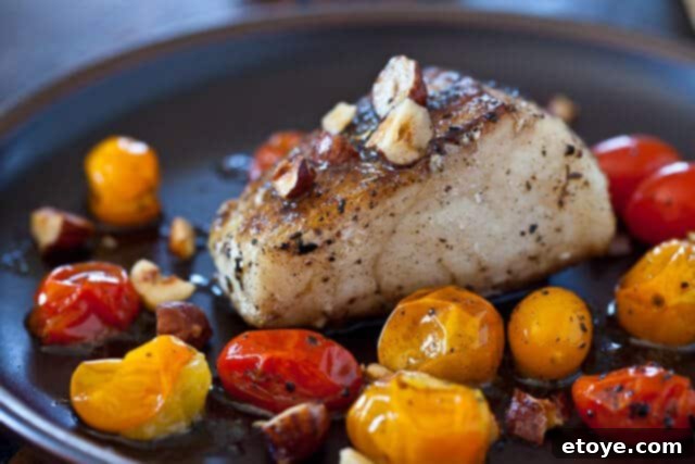 Cherry Tomatoes Sautéing in a Pan with Cod Fish