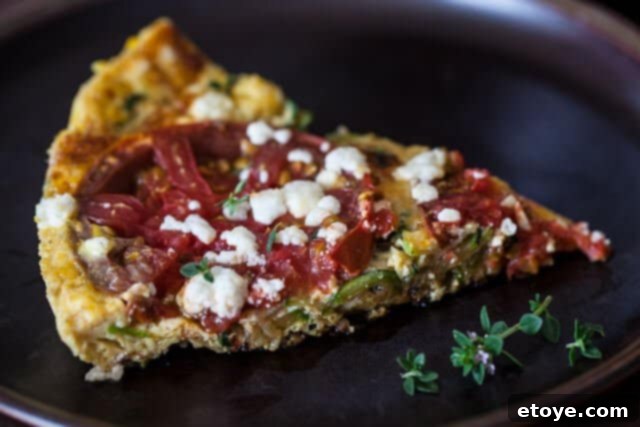 A golden slice of Zucchini Frittata, showcasing fresh vegetables