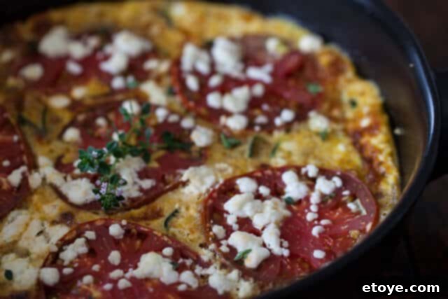 Assortment of fresh eggs, a giant zucchini, and an heirloom tomato for the frittata