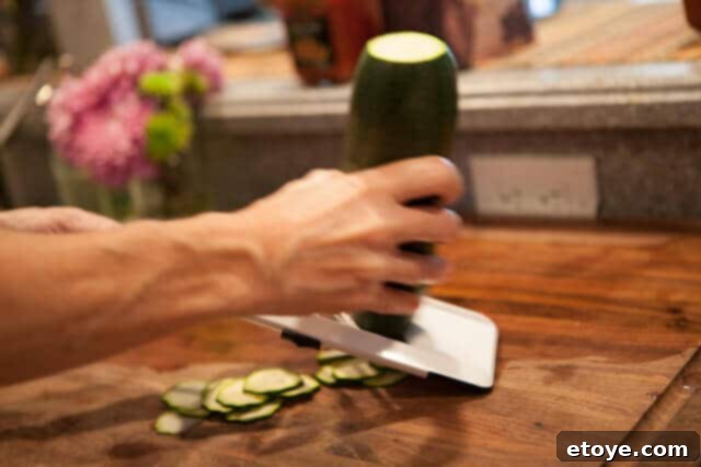 Expertly slicing zucchini for the frittata using a mandoline