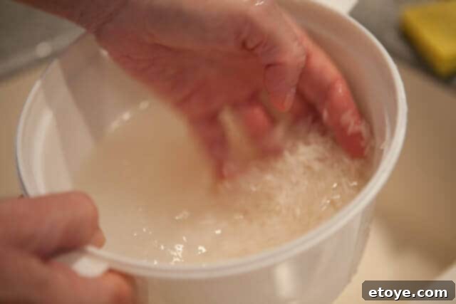 Thoroughly washing rice before microwave cooking, to remove excess starch and impurities