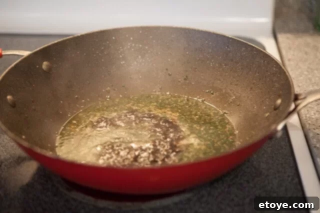 Adding Caramel Sauce to the Braise Sauce in Wok - Caramel sauce being poured into the wok