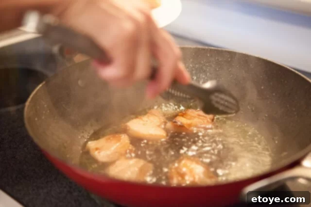 Pork Belly Gently Simmering Pork Belly in Sauce - Sliced pork belly simmering in the caramel sauce