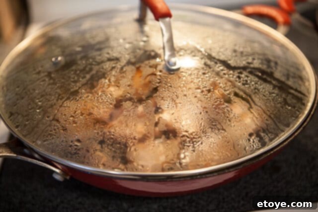Caramel Pork Belly Braising to Perfection Simmering Pork Belly - Wok with pork belly and sauce covered and simmering