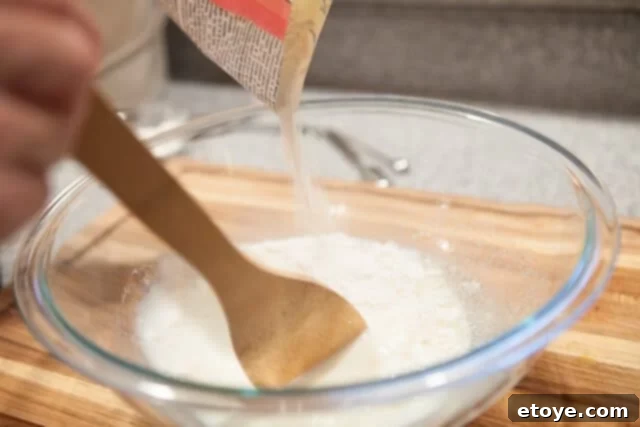 Mixing Steamed Bun Dough Pouring Flour into Wet Ingredients - Adding flour to liquid ingredients in a bowl