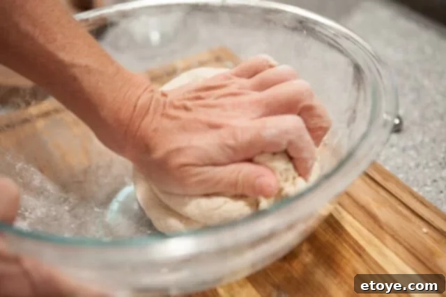 Developing Dough Elasticity for Soft Buns Kneading Steamed Bun Dough - Hands kneading dough on a floured surface