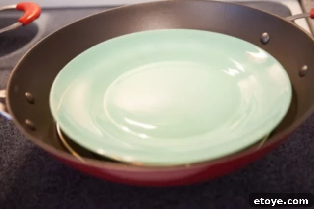 Steaming Plate Ready Steaming Plate in Wok - Heatproof plate placed on a steaming rack in a wok