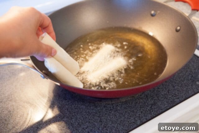Carefully Slide Spring Rolls into Wok
