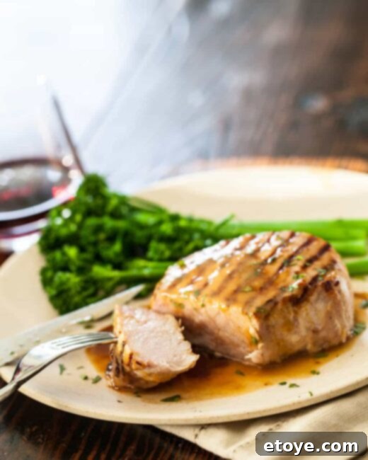 Beautifully seared Whiskey Miso Pork Chops, garnished with fresh herbs, resting on a serving platter
