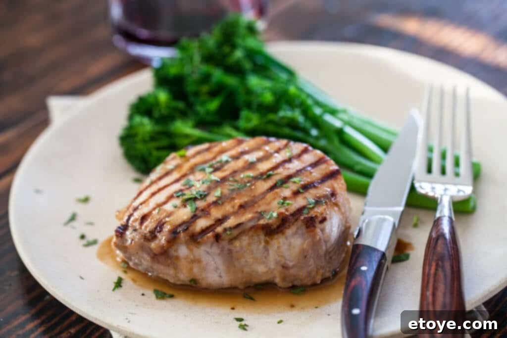 Close-up shot of raw pork chops coated in a rich Whiskey Miso marinade, ready for cooking