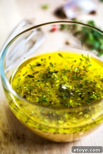 Homemade Zesty Greek Dressing 4 Greek Dressing with herbs in glass bowl