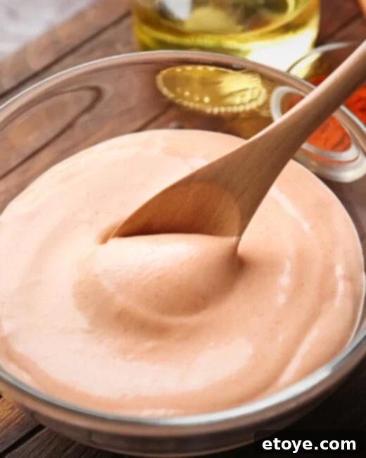 Zesty Creamy Taco Salad Dressing 3 A bowl of creamy taco salad dressing, perfect for enhancing any meal, with fresh ingredients in the background.