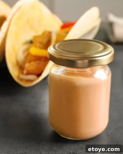 Zesty Creamy Taco Salad Dressing 4 Three jars of homemade creamy taco salad dressing, showcasing its rich texture and appetizing appeal.