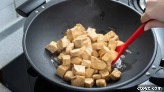Mastering Tofu A Versatile Cooking Guide 4 Cooking diced cubed dried tofu on gas stove.
