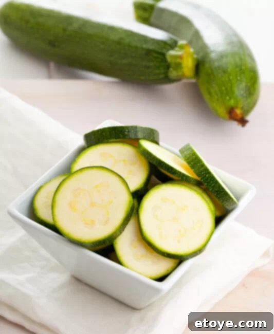 Simple Sauteed Zucchini 3 Fresh organic zucchini sliced in bowl on wooden table