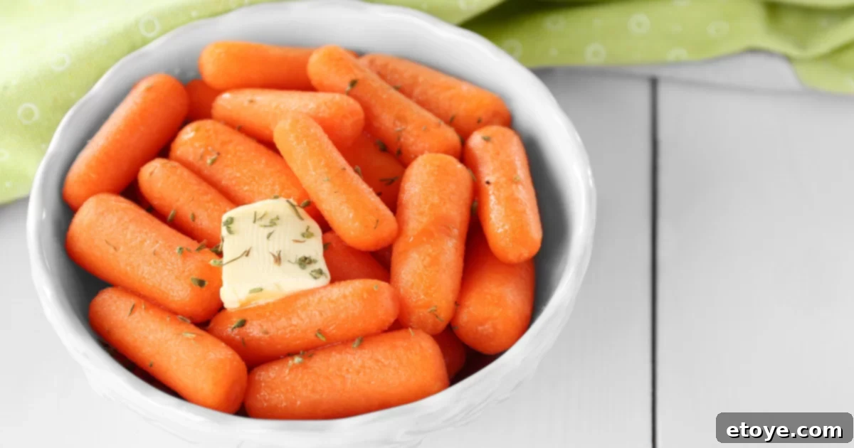 Steamed Carrots with butters and spices in a white bowl and green towel
