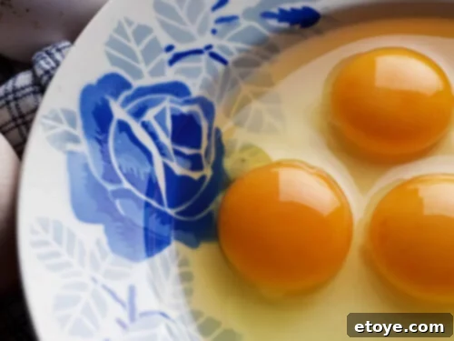 3 egg yolks in a fancy blue bowl