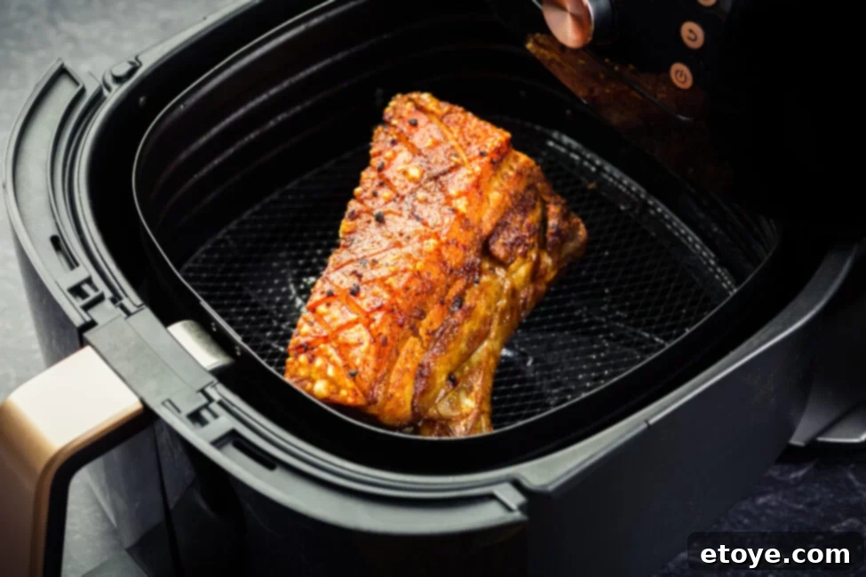 Pork cooking in an air fryer basket