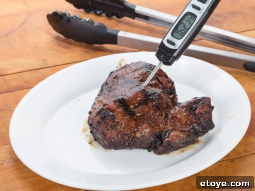 Pan-seared and oven-finished steak on a cutting board, ready to be sliced