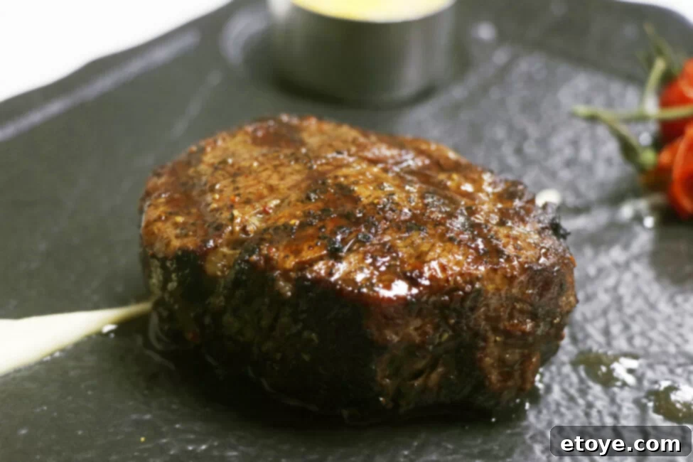 Close-up of a perfectly cooked beef tenderloin fillet steak on a white serving plate