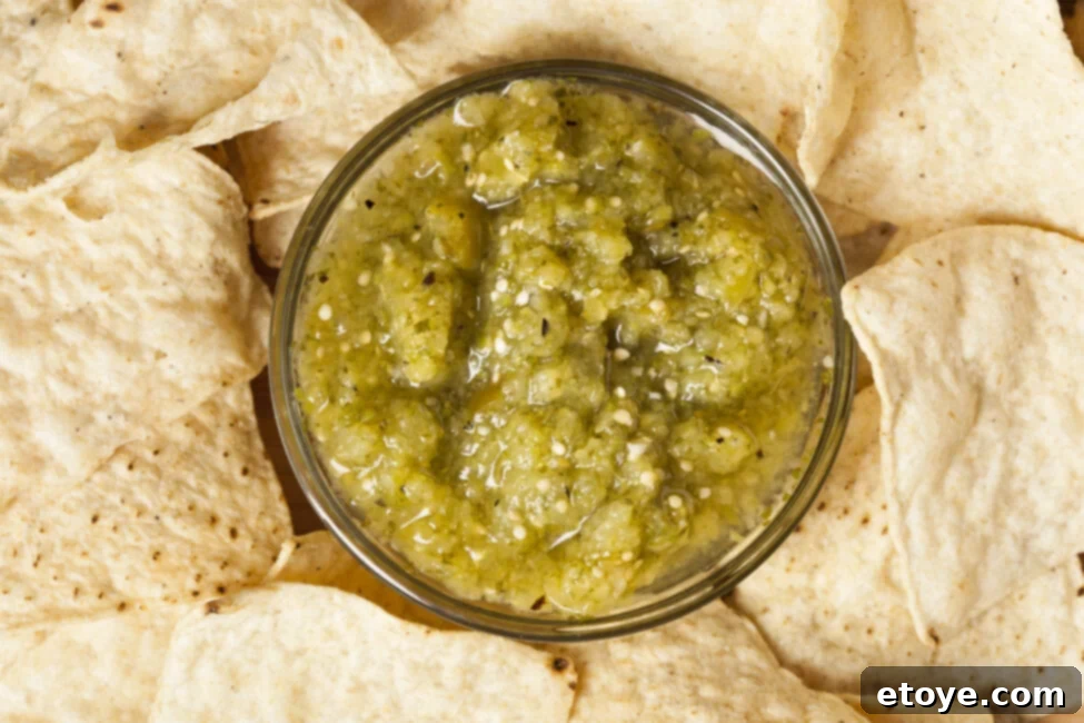 A bowl of salsa verde with some mold spots, indicating spoilage, next to a fresh bowl for contrast