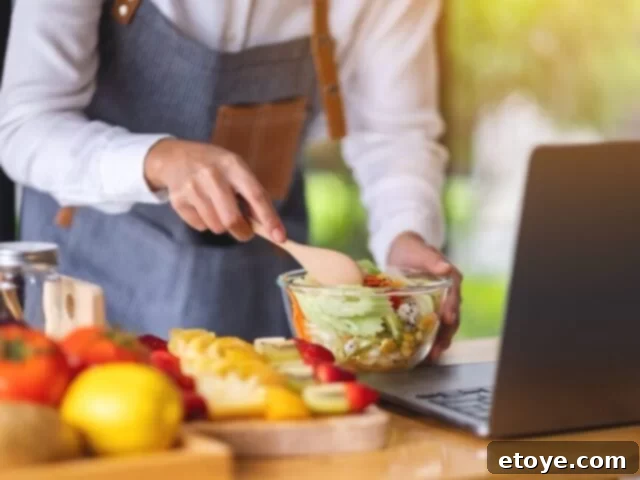 Top 5 Online Cooking Programs to Master Your Kitchen Skills 2 A person enthusiastically participating in an online cooking class from home, chopping vegetables on a cutting board.