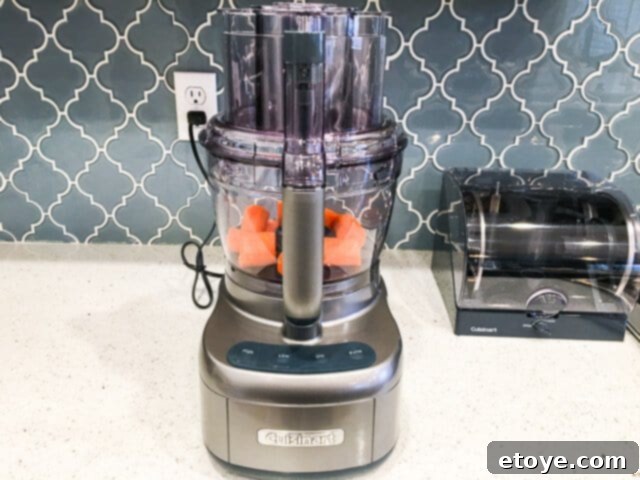 Getting Started With Your Food Processor 2 Food processor parts laid out on a kitchen counter for assembly.
