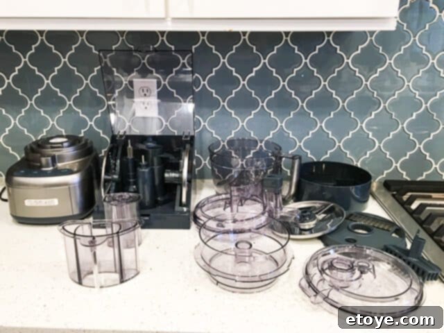 Getting Started With Your Food Processor 6 A person carefully cleaning a disassembled food processor on a kitchen counter.