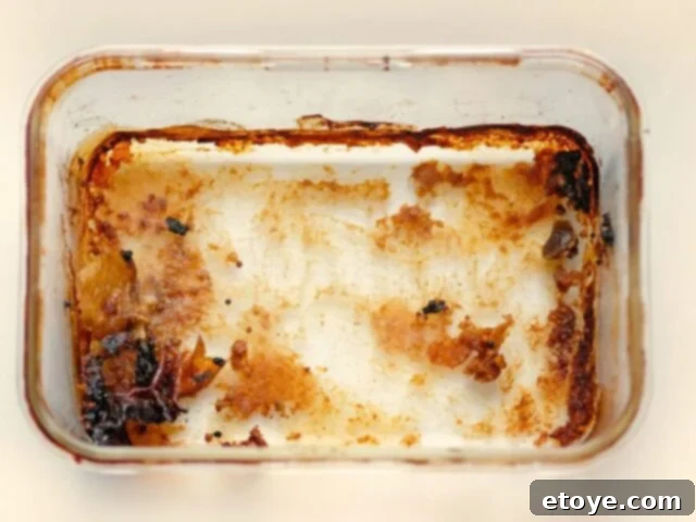 A dirty glass casserole dish with baked-on food