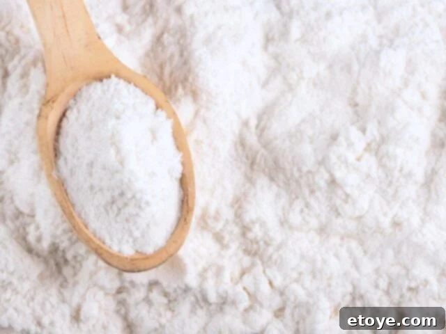 Baking soda and a wooden spoon, highlighting its natural cleaning properties