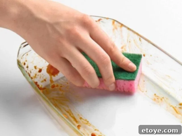 Cleaning a glass casserole dish with a sponge