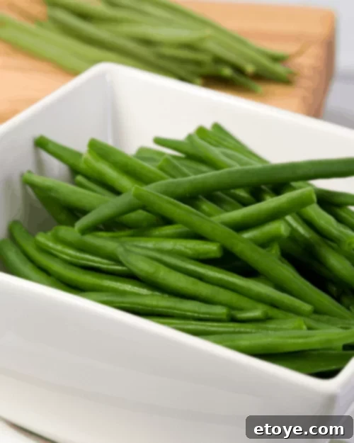 Summer Vegetable Harvest Your Ultimate Guide 2 Freshly steamed green beans in a bowl, glistening with a hint of olive oil and garlic, ready to be served as a healthy side dish.