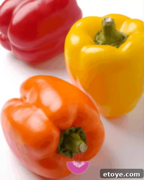 Summer Vegetable Harvest Your Ultimate Guide 3 Vibrant bell peppers in a rainbow of colors including red, yellow, orange, and green, showcasing their fresh appearance and versatility.