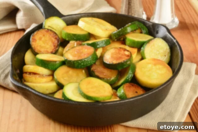 Summer Vegetable Harvest Your Ultimate Guide 5 A vibrant stir-fry of sliced zucchini and yellow summer squash, glistening in a cast iron skillet, ready to be served.