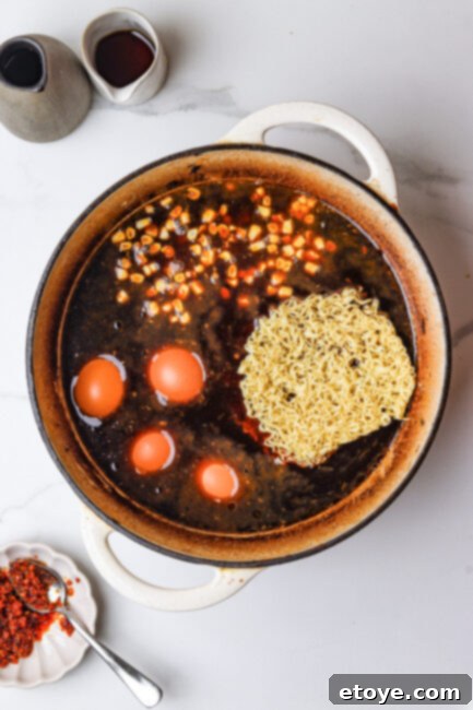 Cooking ramen noodles, eggs, and corn in broth
