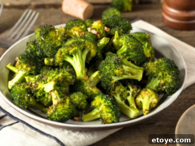 The Ultimate Guide to Fall Vegetables 4 Freshly cooked broccoli florets on a white plate, ready to be served.