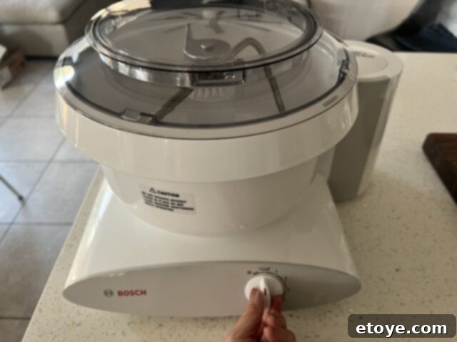 Bosch Universal Plus Kitchen Mixer Deep Dive 2 Bosch Universal Plus Kitchen Stand Mixer in white, showcasing its sleek design on a kitchen counter.